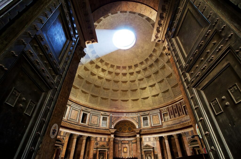 Interior of the Pantheon in Rome with sunlight streaming through the oculus onto the coffered dome